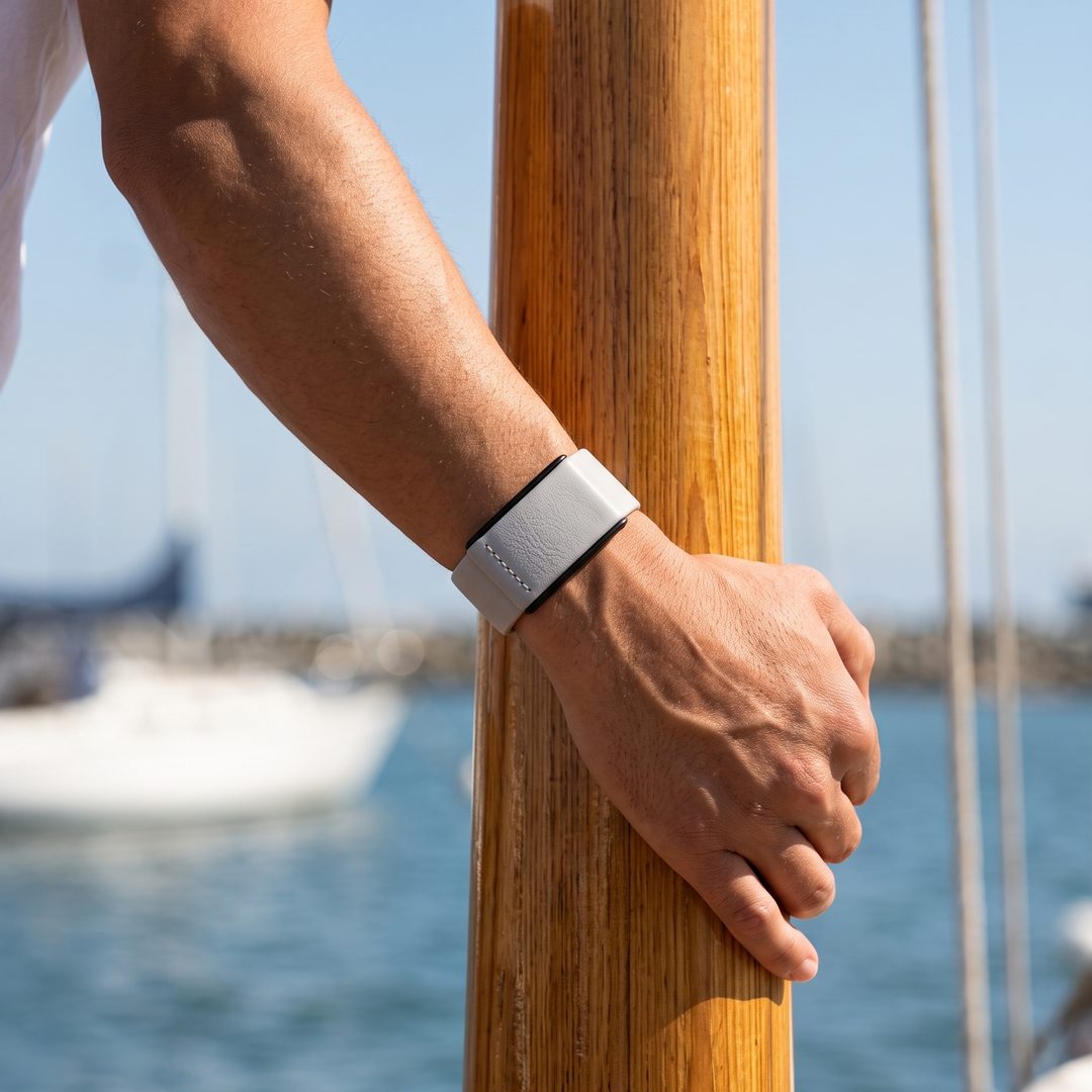 Ecoband 5.0 in Cloud worn on a sailing boat, hand on a wooden mast (cloud)