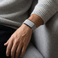 Ecoband 5.0 in Cloud worn with a grey knit sweater, at rest on a sofa (cloud)