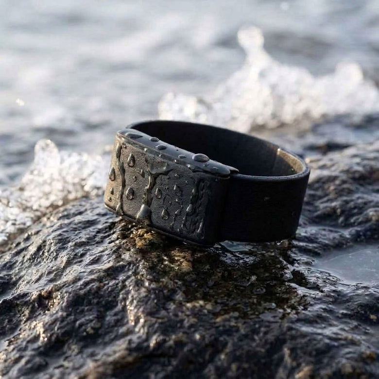 Ecoband 5.0 in Black — fast-drying WHOOP band on wet rock by the sea (black)