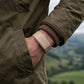 Ecoband 5.0 in Sand worn on a hillside walk, hand in jacket pocket (Sand)