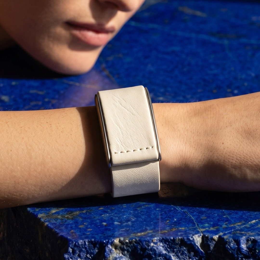 Ecoband 5.0 in Bianco worn on the wrist, resting on lapis lazuli stone (Bianco)
